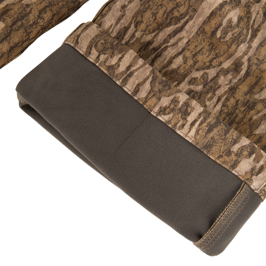 Close-up of the MST Youth CommandXT Softshell Pant leg cuff, featuring a dark brown panel at the hem and a brown camouflage pattern.