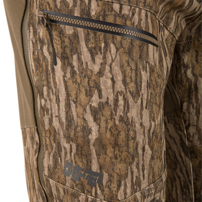 Close-up of MST Youth CommandXT Softshell Pant windproof camouflage pants featuring a zippered side pocket and the word COMMAND printed near the hem.