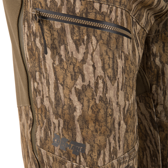 Close-up of MST Youth CommandXT Softshell Pant windproof camouflage pants featuring a zippered side pocket and the word COMMAND printed near the hem.