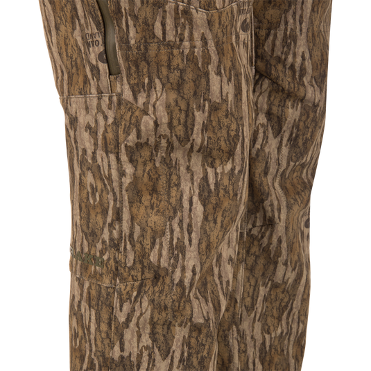 Close-up of MST Youth CommandXT Softshell Pant camouflage hunting pants, featuring windproof, water-resistant fabric, zippered side pockets, and a stretch waistband.