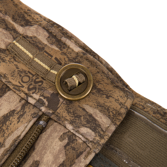 Close-up of an MST Youth CommandXT Softshell Pant brown camouflage waistband, featuring a metal button, a zipper, and a webbing loop.