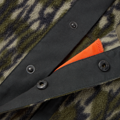 Close-up of the Camp Fleece Limited Edition Snap Pullover, featuring camouflage fleece, black snap-button flap, and bright orange interior trim peeking through.