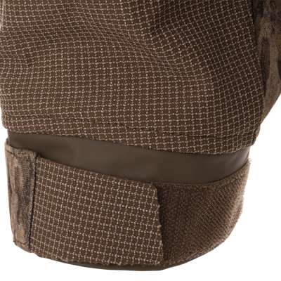 Close-up of LST CommandXT 3-in-1 PrimaLoft Insulated Jacket's check-patterned textile strap with Velcro closure, highlighting its rugged construction for all-weather adaptability.