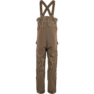 LST CommandXT Bib with Primaloft features camouflage overalls, adjustable suspenders, and reinforced panels, designed for warmth and durability in extreme hunting conditions.