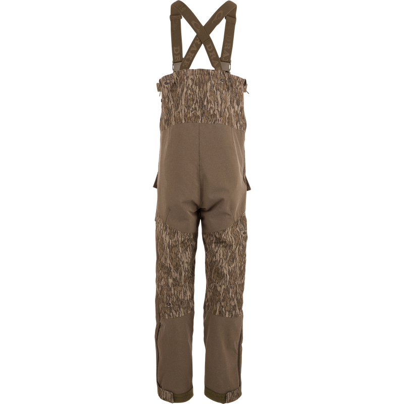 LST CommandXT Bib with Primaloft features camouflage overalls, adjustable suspenders, and reinforced panels, designed for warmth and durability in extreme hunting conditions.