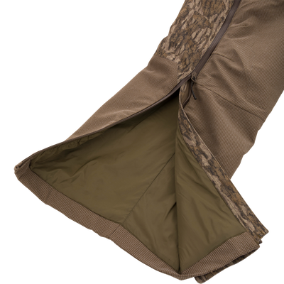 LST CommandXT Bib with Primaloft shown with camo shell, revealing olive lining and side zipper, highlighting its warmth and durability for extreme hunting conditions.