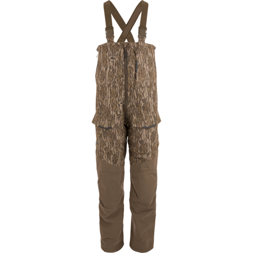 LST CommandXT Bib with Primaloft, featuring camouflage design, adjustable suspenders, multiple pockets, and front zipper; ideal for blending into woodland hunting environments.