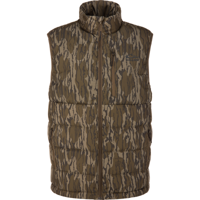 BMF Drake Down Vest in Mossy Oak pattern with high collar, full-length zipper, and multiple pockets, designed for core warmth and mobility in tough hunting conditions.