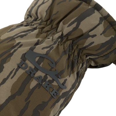 Close-up of an LST Down Lobster Mitten showcasing quilted camouflage fabric, silicone-printed palm, and adjustable wrist closure for cold-weather hunting and fishing.