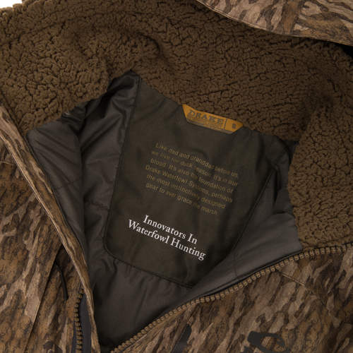 Inside view of Drake Waterfowl's LST BMF Eqwader Full Zip with Primaloft, showcasing the sherpa collar and branded lining with story and slogan.