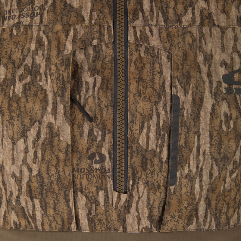 Close-up of LST BMF Eqwader Half Zip Jacket with Primaloft, featuring a central zipper, zippered chest pocket, and Mossy Oak Bottomland logo, ideal for hunting.