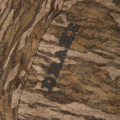 Close-up of LST BMF Eqwader Half Zip Jacket with Primaloft featuring a DRAW. seam detail, showcasing its woodland camouflage pattern and durable construction.