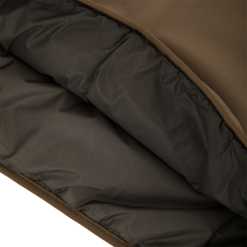Close-up of the LST BMF Eqwader Half Zip Jacket showing its brown shell and quilted insulated lining for warmth and protection in harsh weather.