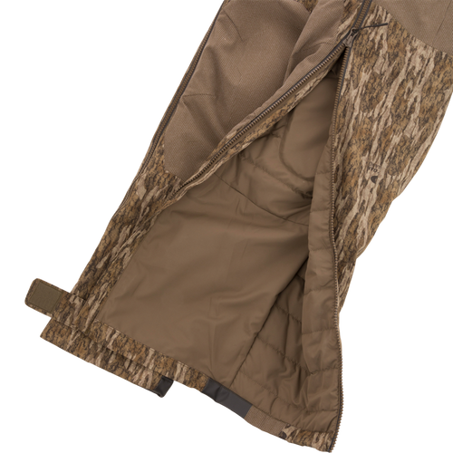 LST BMF Pit Bib with Primaloft, showcasing camo outer shell, quilted lining, long zipper, Velcro ankle strap, and boot hooks for rugged hunting conditions.