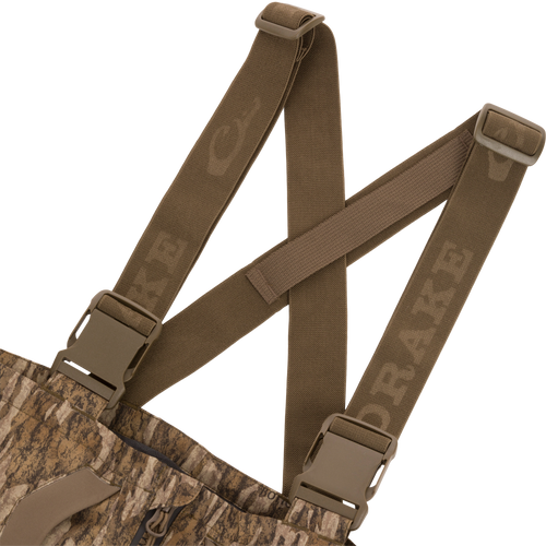 LST BMF Pit Bib with Primaloft features camo fabric, adjustable olive-brown suspenders with quick-release buckles, and a zippered fly for rugged outdoor performance.