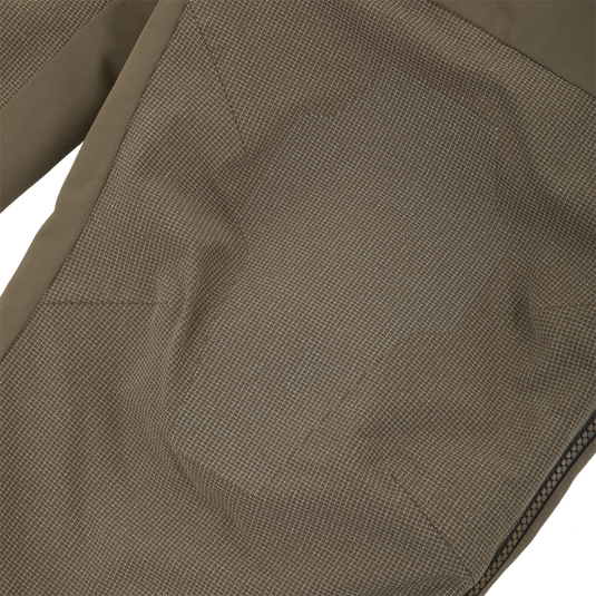 Close-up of olive green Drake X Ducks Unlimited LST BMF Pit Bib with Primaloft pants featuring a reinforced, textured panel on the knee and a side zipper.