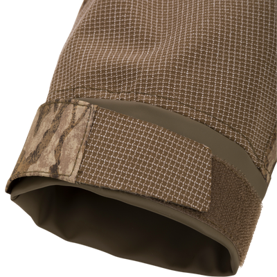 Close-up of the LST BMF Pit Jacket's cuff, highlighting the durable grid-patterned fabric and camouflage Velcro strap for secure fit in extreme outdoor conditions.