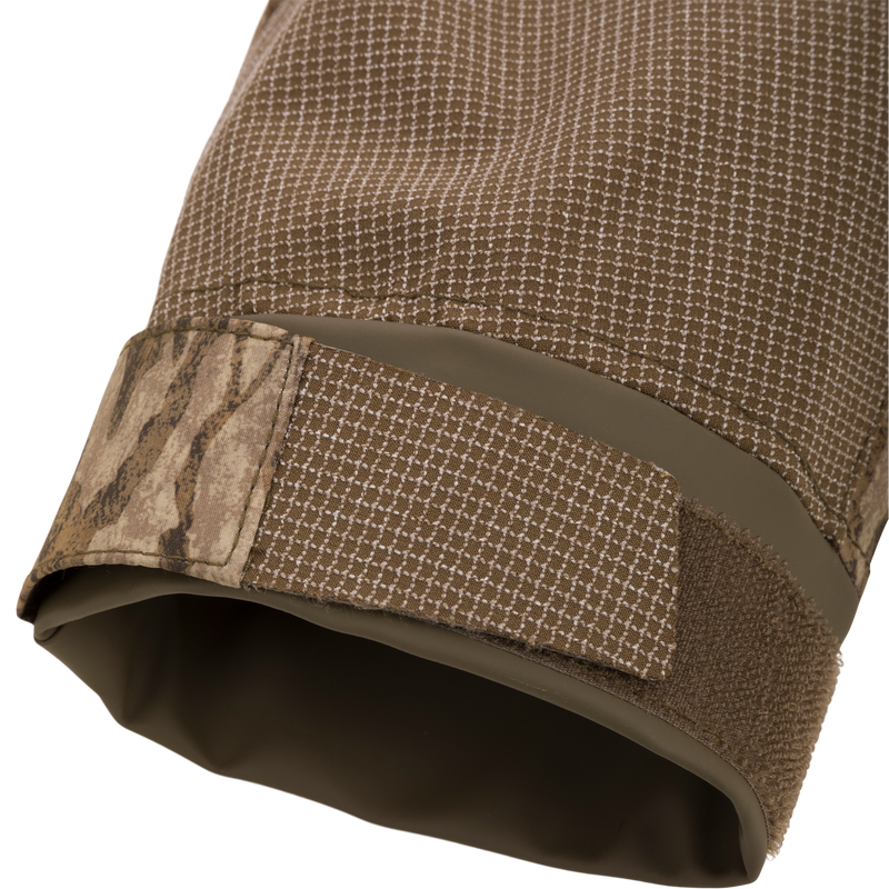 Close-up of the LST BMF Pit Jacket's cuff, highlighting the durable grid-patterned fabric and camouflage Velcro strap for secure fit in extreme outdoor conditions.