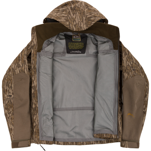 Drake Waterfowl LST BMF Pit Jacket with camo exterior, unzipped to show gray lining and label. Designed for extreme conditions with durable, weather-resistant features.