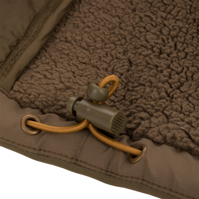 Close-up of LST BMF 3-in-1 Pit Jacket's chocolate-brown sherpa fleece lining with olive-green binding, tan drawcord, and cord-lock toggle, highlighting its rugged construction.