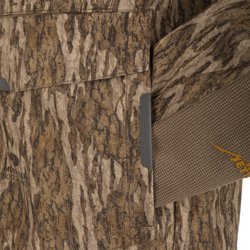 Close-up of the LST BMF 3-in-1 Pit Jacket with Mossy Oak camo, showcasing textured fabric, Velcro pocket flap, and adjustable strap with META. detailing.