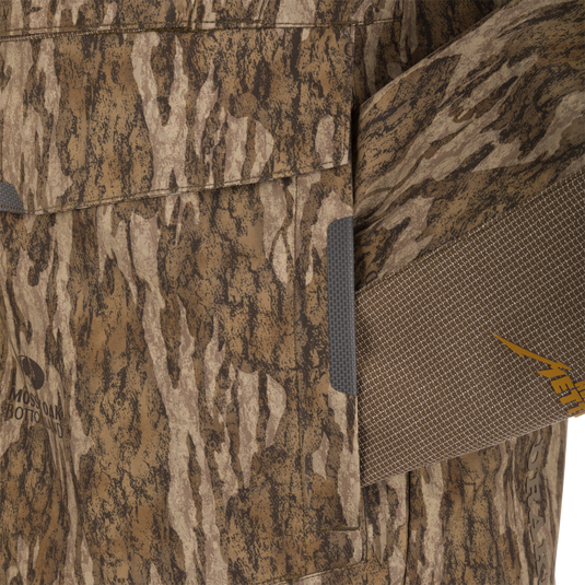 Close-up of the LST BMF 3-in-1 Pit Jacket with Mossy Oak camo, showcasing textured fabric, Velcro pocket flap, and adjustable strap with META. detailing.