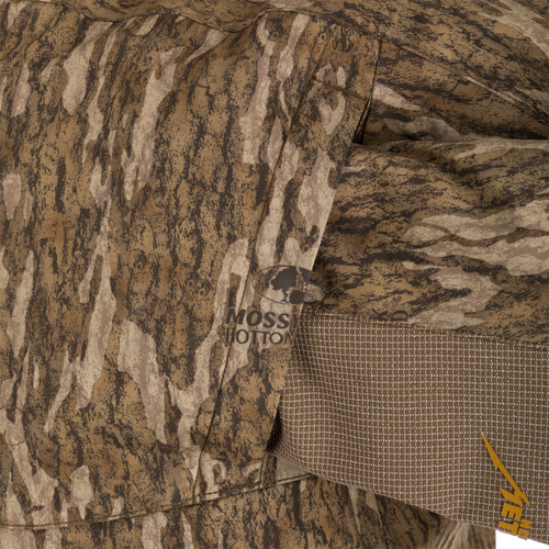 Close-up of the LST BMF 3-in-1 Pit Jacket with Primaloft, showcasing Mossy Oak Bottomland camo pattern, stitched pocket, and YETI logo.