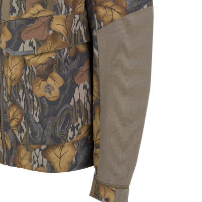 Drake X Ducks Unlimited LST BMF 3-in-1 Pit Jacket with Primaloft camouflage waterfowl hunting jacket featuring a textured solid-colored panel on the sleeve and a Mossy Oak Fall Foliage logo patch.