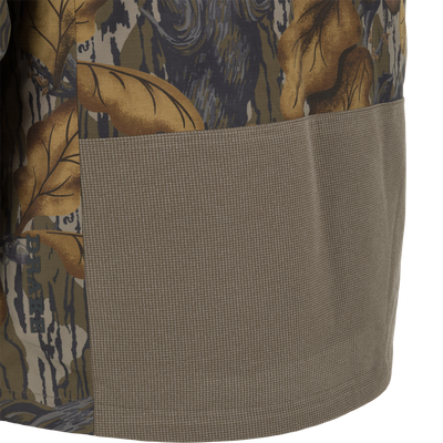 Close-up of a Drake X Ducks Unlimited LST BMF 3-in-1 Pit Jacket with Primaloft, showing a large, solid olive-green reinforced panel on the lower section.