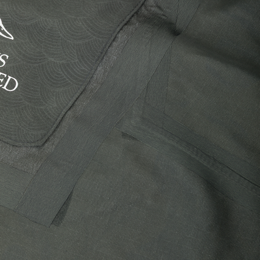 Close-up of the interior of a Drake X Ducks Unlimited LST BMF 3-in-1 Pit Jacket with Primaloft, showing dark grey heat-sealed seams and a partial logo.
