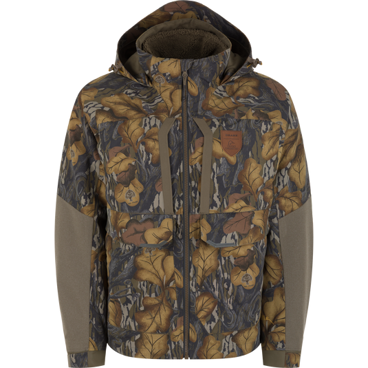 Mossy Oak Fall Foliage Drake X Ducks Unlimited LST BMF 3-in-1 Pit Jacket with Primaloft featuring a camo pattern, hood, chest pockets, zipper closure, and solid-colored panels on the sleeves.