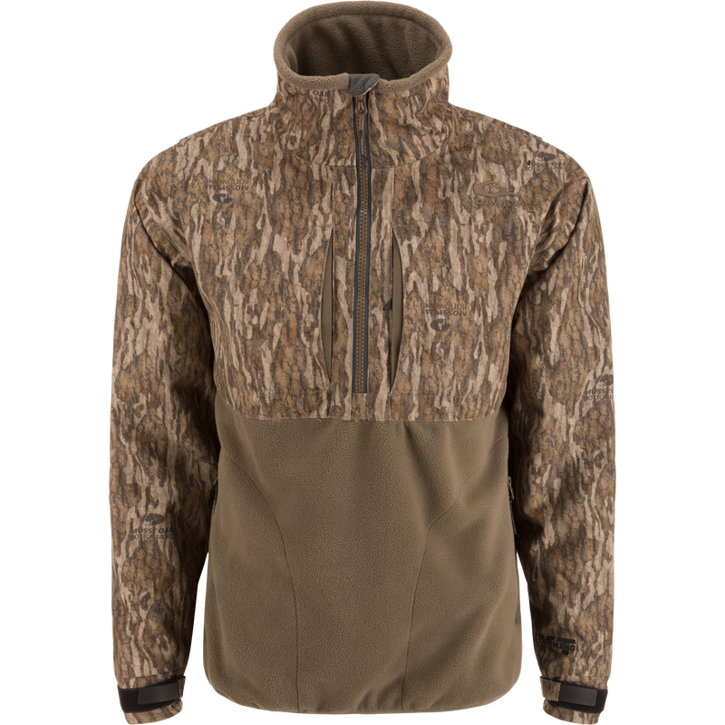 MST CommandXT Eqwader Half Zip Jacket with camo-patterned upper, olive fleece lower, zippered chest pockets, storm flap, and adjustable cuffs, ideal for rugged outdoor use.