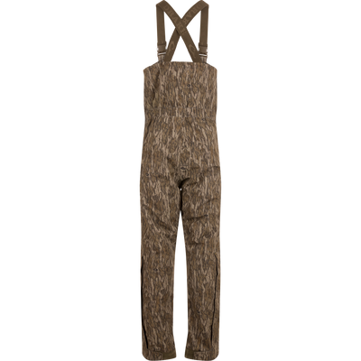 LST Hardline Insulated Bib, camouflage-patterned, features adjustable suspenders, waterproof polyester, synthetic down insulation, YKK zippers, and articulated knees, ideal for harsh outdoor conditions.