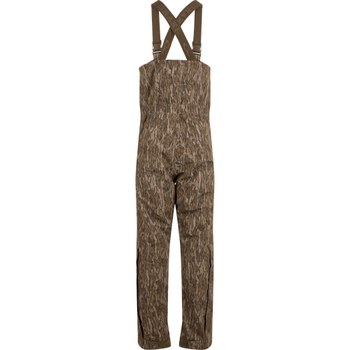 LST Hardline Insulated Bib, camouflage-patterned, features adjustable suspenders, waterproof polyester, synthetic down insulation, YKK zippers, and articulated knees, ideal for harsh outdoor conditions.