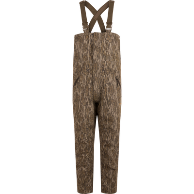 LST Hardline Insulated Bib designed for wooded hunting, features durable waterproof fabric, synthetic insulation, and functional zippers for easy wear in harsh environments.