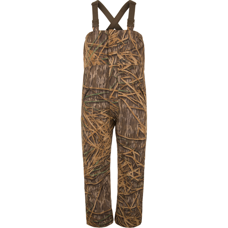 LST Hardline Insulated Bib with adjustable straps, grass camo print, waterproof polyester, synthetic down insulation, tricot-lined pockets, and articulated knees for waterfowl hunting.