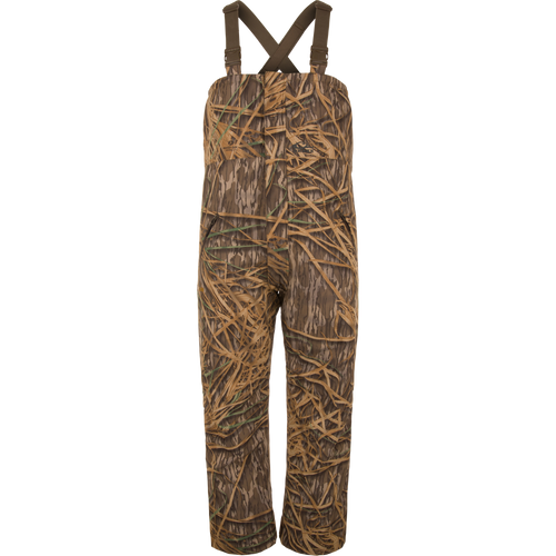 LST Hardline Insulated Bib with adjustable straps, grass camo print, waterproof polyester, synthetic down insulation, tricot-lined pockets, and articulated knees for waterfowl hunting.