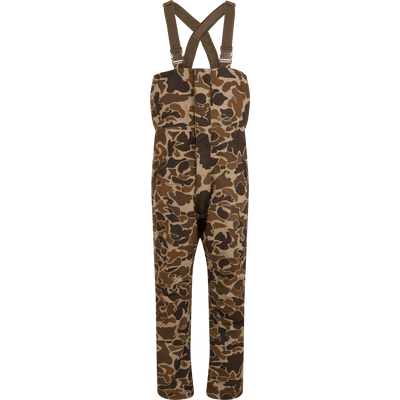 LST Hardline Insulated Bib with camo pattern, adjustable suspenders, and storm-resistant zippers, designed for warmth and mobility in harsh outdoor conditions.