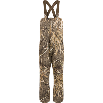 LST Hardline Insulated Bib: Camouflage overalls with adjustable straps, durable waterproof polyester, insulated for warmth, featuring handwarmer pockets, storm flaps, and articulated knees for hunting.