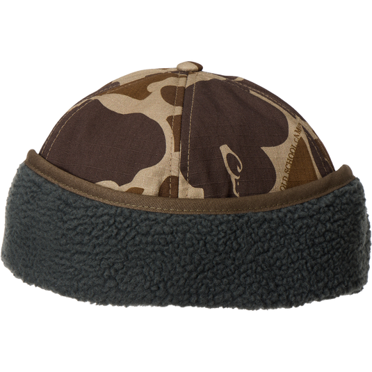 MST Flap Cap with camouflage print, dark gray sherpa cuff, and fold-down ear flaps, ideal for outdoor adventures in cold weather.