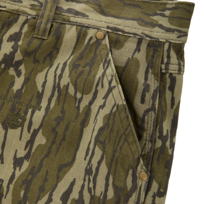 Close-up of Men's Throwback80 Field Pant waistband, showcasing camouflage pattern, belt loop, and antique brass riveted pocket, emphasizing durability and rugged style.