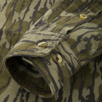 Close-up of the Throwback 80 Field Shirt, showcasing tiger-stripe camo pattern, durable triple-needle stitching, and reinforced forearm and elbow areas for hunting durability.