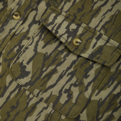 Close-up of the Throwback 80 Field Shirt, showcasing its tiger-stripe camo pattern, flap pocket, and durable construction with reinforced stitching and elbow layers.