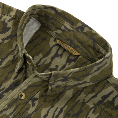 Throwback 80 Field Shirt collar close-up, featuring tiger-stripe camo print, DRAKE'S button, and size label. Crafted from durable cotton twill with reinforced stitching.