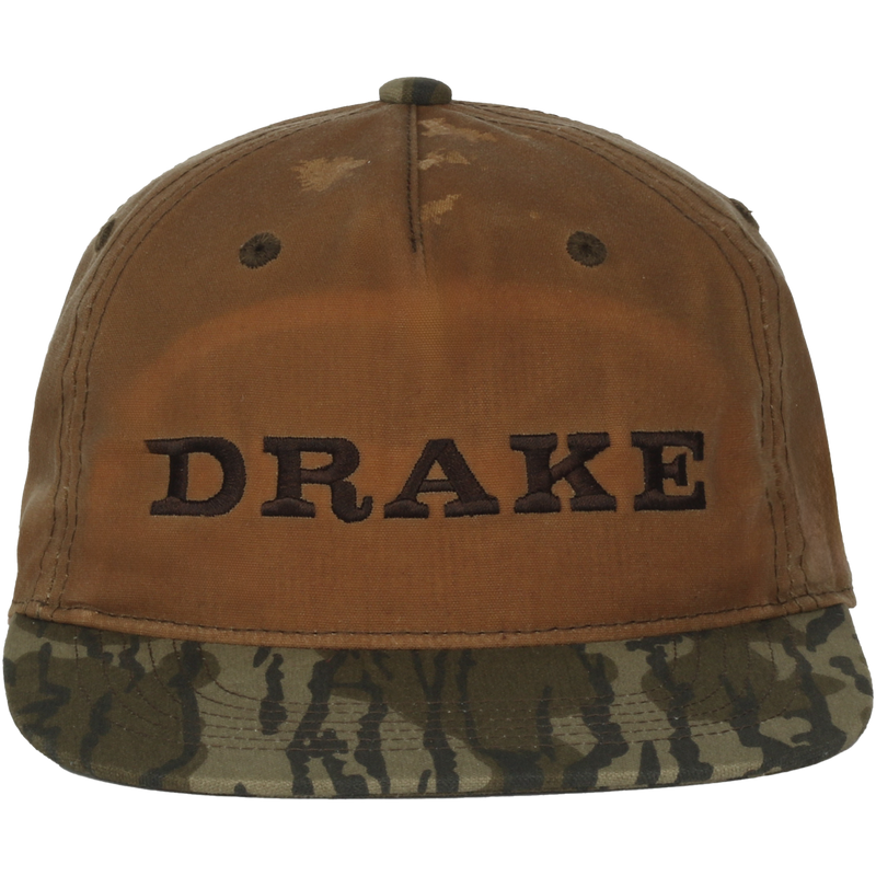 Waxed Flatbill Ball Cap with a worn brown canvas crown and camouflage brim, featuring DRAKE embroidery, offering a stylish and comfortable fit.