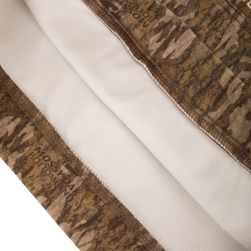 Close-up of the Youth Performance Hoodie, featuring Mossy Oak's Bottomland camouflage with white fleece backing and serged seams, designed for comfort and versatility in outdoor activities.