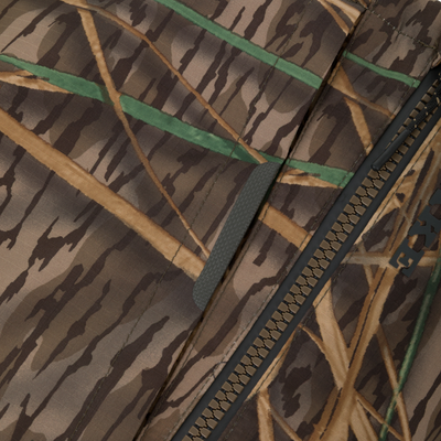 Close-up of BMF Uninsulated Pit Bib's camo ripstop fabric with visible zipper, highlighting its durable, waterproof design and rugged construction for harsh hunting conditions.