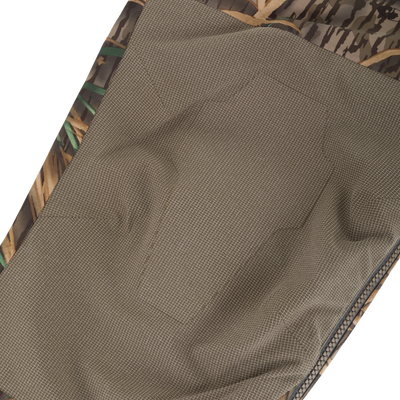Close-up of BMF Uninsulated Pit Bib's inside, showing tan grid-patterned lining, camo binding, and zipper track, highlighting its durable and adaptable design.