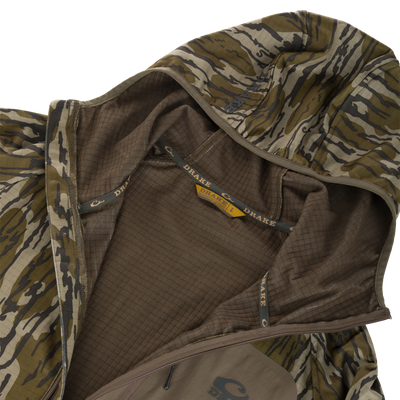 Grid Fleece Half Zip Hoodie with tiger stripe camo, partially unzipped to show grid-fleece lining, taped seams, and a zippered chest pocket with DRAKE logo.