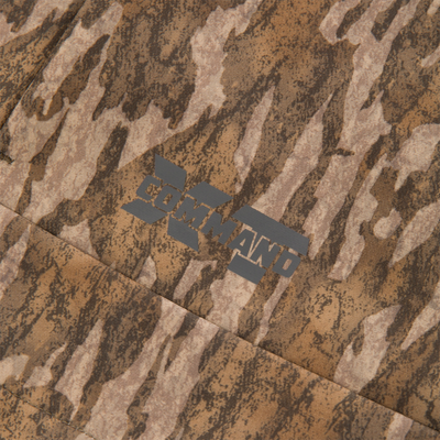 Close-up of MST CommandXT Softshell Vest showcasing brown camouflage fabric with partial COMMAND logo, highlighting its flexible, weather-resistant design for outdoor use.